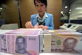 Kiểm tiền baht của Thái Lan tại ngân hàng ở Bangkok. (Ảnh: AFP/TTXVN)