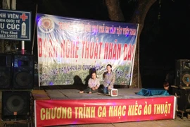 Lợi dụng lòng thương của nhiều người qua đường, các đối tượng ngang nhiên biểu diễn khoác áo từ thiện kiếm tiền. (Ảnh: Quỳnh Trang/Vietnam+)