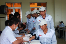 Lao động được kiểm tra sức khỏe trước khi lên máy bay sang Hàn Quốc. (Ảnh: Hồng Kiều/Vietnam+)