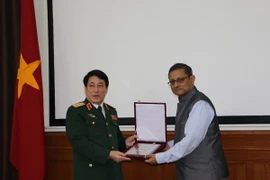 Lãnh đạo hai bên trao biểu tượng. (Ảnh: Huy Bình-Minh Luyến/Vietnam+)