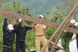 Cán bộ, chiến sỹ Công an tỉnh Đắk Lắk dựng lại nhà cho người dân huyện Krông Bông. (Ảnh: Phạm Cường/TTXVN)