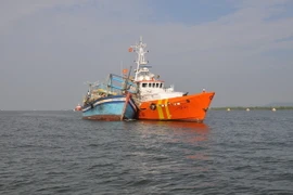 Tàu SAR 413 cứu hộ một tàu cá. (Ảnh: Đoàn Mạnh Dương/TTXVN)