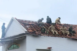 Bộ đội Biên phòng lợp lại mái nhà cho người dân. (Ảnh: Phước Ngọc/TTXVN)