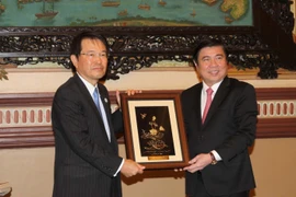 Chủ tịch Ủy ban Nhân dân Thành phố Hồ Chí Minh Nguyễn Thành Phong tặng quà lưu niệm Chủ tịch Phòng Thương mại và Công nghiệp Osaka Hiroshi Ozaki. (Ảnh: Thanh Vũ/TTXVN)