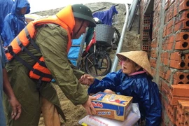 Lực lượng Cảnh sát đường thủy, Công an tỉnh Thừa Thiên-Huế cứu trợ lương thực cho người dân xã Phú Mậu, huyện Phú Vang. (Ảnh: Hồ Cầu/TTXVN)