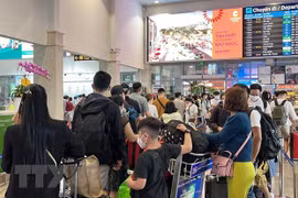 Hành khách làm thủ tục chuyến bay tại sân bay Tân Sơn Nhất. (Ảnh: Tiến Lực/TTXVN)