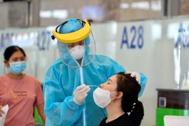 Lấy mẫu xét nghiệm COVID-19 nhanh với hành khách bay. (Ảnh: CTV/Vietnam+)