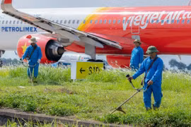 Nhân viên sân bay Nội Bài vẫn căng mình làm việc dưới tiết trời nắng nóng như thiêu đôt. (Ảnh: CTV/Vietnam+)