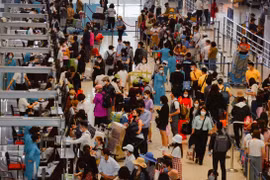 Hành khách làm thủ tục tại quầy máy bay của Vietnam Airlines. (Ảnh: CTV/Vietnam+)