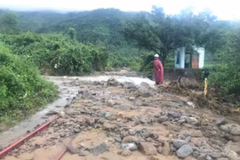 Mưa lũ miền Trung khiến đất đá đổ tràn đường ray, tàu Bắc-Nam gián đoạn. (Ảnh: CTV/Vietnam+)