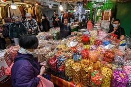Người dân mua sắm tại một chợ ở Hong Kong, Trung Quốc, ngày 13/1. (Ảnh: AFP/TTXVN)