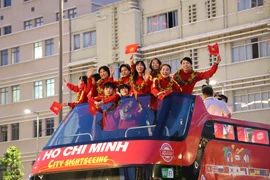 Các thành viên đội tuyển bóng đá nữ Việt Nam hào hứng trong lễ diễu hành. (Ảnh: Hồng Giang/TTXVN)
