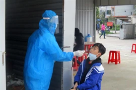 Nhân viên y tế tỉnh Thanh Hóa lấy mẫu xét nghiệm COVID-19 cho học sinh. (Ảnh: Nguyễn Nam/TTXVN)