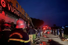 Các lực lượng chức năng cố gắng dập tắt đám cháy. (Ảnh: TTXVN phát)