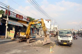 Thi công hạ tầng giao thông tại TP.HCM trong những ngày cận Tết. (Ảnh: Tiến Lực/TTXVN)