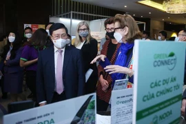 Phó Thủ tướng Thường trực Phạm Bình Minh và các đại biểu tham quan trưng bày các sản phẩm kinh tế xanh và bảo vệ môi trường. (Ảnh: Lâm Khánh/TTXVN)