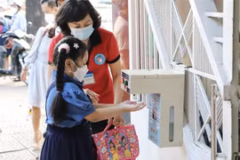 Học sinh trường tiểu học Hoà Bình (Quận 1) được giáo viên hướng dẫn rửa tay trước khi vào lớp. (Ảnh: Hồng Giang/TTXVN)