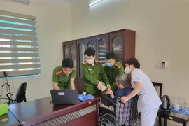 Công an Quảng Ninh thực hiện các bước cấp căn cước công dân cho người tàn tật. (Ảnh: TTXVN phát)