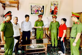 Cơ quan Cảnh sát điều tra Công an tỉnh Thanh Hóa thi hành Lệnh bắt tạm giam đối với Nguyễn Thị Minh (áo đỏ). (Ảnh: Công an cung cấp)