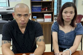 Hai đối tượng Phạm Tuấn Linh và Đinh Thị Bích Ngọc tại cơ quan công an. (Ảnh: TTXVN phát)