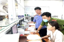 Lực lượng chức năng tiến hành khám xét các phòng khám đa khoa có liên quan. (Ảnh: TTXVN phát)
