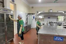 Nhân viên lau dọn khu vực bếp tại Trường Mẫu giáo số 3. (Ảnh: PV/Vietnam+)