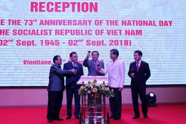 Đại sứ Việt Nam tại Lào Nguyễn Bá Hùng (giữa) cùng các lãnh đạo Lào mừng Quốc khánh Việt Nam. (Ảnh: Phạm Kiên/TTXVN)