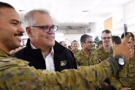 Thủ tướng Scott Morrison (áo đen) chụp ảnh chung với binh sỹ Australai tại khu quân sự tại tỉnh Taji. (Nguồn: AP)