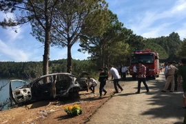 Cơ quan chức năng trục vớt chiếc xe tại hiện trường. (Ảnh: Hồng Điệp/TTXVN)