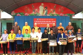 Lãnh đạo Giáo hội Phật giáo Việt Nam trao quà cho người dân xã Lùng Tám, bị thiệt hại nặng nề do mưa lũ gây ra. (Ảnh: Minh Tâm/TTXVN)