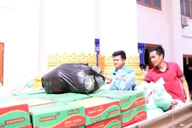 Nhiều tổ chức mang nhiều đồ cứu trợ và tiền tới ủng hộ người dân bị nạn ngày 25/7. (Ảnh: Phạm Kiên/TTXVN)