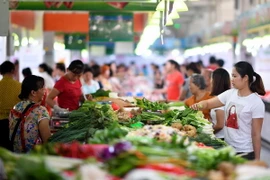 Người dân mua sắm tại một khu chợ ở Hải Nam, Trung Quốc. (Ảnh: AFP/TTXVN)