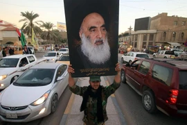 Một thành viên của Hashed al-Shaabi cầm ảnh chân dung của Đại giáo chủ Ali al-Sistani. (Nguồn: AFP)