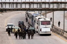Đoàn xe sơ tán lực lượng nổi dậy và gia đình tại Đông Ghouta ngày 23/3. (Nguồn: THX/TTXVN)