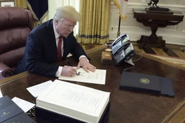 Tổng thống Mỹ Donald Trump ký ban hành một đạo luật. (Ảnh: AFP/TTXVN)