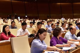 Các đại biểu Quốc hội bấm nút thông qua Luật An ninh mạng. (Ảnh: Dương Giang/TTXVN)