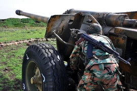 Binh sỹ Chính phủ Syria điều khiển khẩu đội pháo ở khu vực giữa Talbiseh và Rastan, ngoại ô thành phố Homs, Syria ngày 1/3. (Nguồn: AFP/TTXVN)