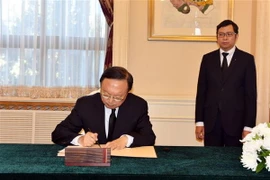 Ủy viên Bộ Chính trị, Chủ nhiệm Văn phòng Ủy ban Công tác đối ngoại của Trung ương Đảng Cộng sản Trung Quốc Dương Khiết Trì viết sổ tang. (Ảnh: Vĩnh Hà/TTXVN)