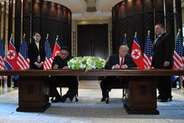Tổng thống Mỹ Donald Trump (thứ 2, phải) và nhà lãnh đạo Triều Tiên Kim Jong-un (thứ 2, trái) ký tuyên bố chung tại hội nghị. (Nguồn: AFP/TTXVN)