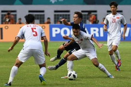 Pha tranh bóng quyết liệt giữa cầu thủ Phạm Đức Huy (thứ 2, phải) của Olympic Việt Nam và Kouta Wanabe (giữa, phía sau) của Olympic Nhật Bản trong trận đấu ở bảng D, ASIAD 2018 ở Cikarang, Indonesia ngày 19/8. (Ảnh: AFP/TTXVN)