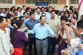 Thủ tướng Campuchia Hun Sen (giữa) gặp gỡ những người ủng hộ sau khi bỏ phiếu tại tỉnh Kandal ngày 25/2. (Nguồn: Kyodo/TTXVN)