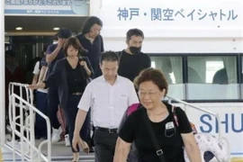Hành khách di chuyển từ sân bay Kansai xuống xuồng cao tốc để sang sân bay Kobe ngày 5/9. (Ảnh: Kyodo/TTXVN)