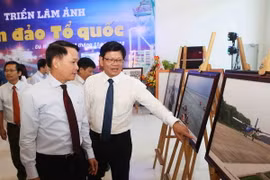 Ủy viên Trung ương Đảng, Tổng Giám đốc Thông tấn xã Việt Nam Nguyễn Đức Lợi và Phó Bí thư thường trực Thành ủy Đà Nẵng Võ Công Trí tham quan Triển lãm ảnh “Biển đảo Tổ quốc”. (Ảnh: Trần Lê Lâm/TTXVN)