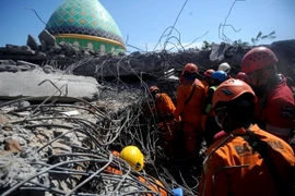 Lực lượng cứu hộ làm nhiệm vụ tại hiện trường đổ nát sau động đất tại Bắc Lombok, Indonesia ngày 8/8. (Ảnh: THX/TTXVN)