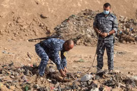 Cảnh sát Iraq khai quật thi thể được tìm thấy trong một ngôi mộ tập thể ở Hamam al-Alil trong chiến dịch giải phóng Mosul ngày 7/11/2017. (Nguồn: AFP/TTXVN)