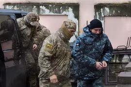 Nhân viên mật vụ thuộc Cơ quan An ninh Liên bang Nga áp giải một thủy thủ Ukraine (phải) bị bắt tới tòa án ở Simferopol, bán đảo Crimea ngày 27/11/2018. (Ảnh: AFP/TTXVN)