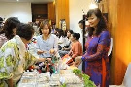 Khách hàng đang lựa chọn các sản phẩm tại gian hàng của Đại sứ quán Việt Nam. (Ảnh: Hải Ngọc/Vietnam+)