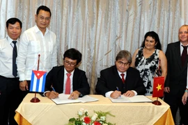 Tổng giám đốc VTV Trần Bình Minh và Chủ tịch Viện Phát thanh-Truyền hình Cuba Alfonso Noya ký thỏa thuận hợp tác. (Ảnh: Vũ Lê Hà/TTXVN)