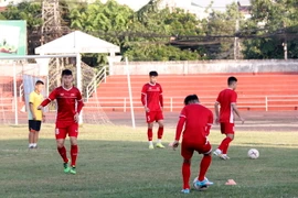 Các cầu thủ đang tập ban chuyền bóng nhẹ nhành trên sân để làm quen với sân và thời tiết tại Lào. (Ảnh: Phạm Kiên/Vietnam+)