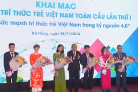Phó Thủ tướng Thường trực Chính phủ Trương Hòa Bình tặng hoa cho các trí thức trẻ. (Ảnh: Đinh Văn Nhiều/TTXVN)